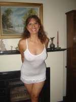Mature Latina in white dress next to fireplace.jpg