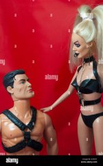 dominatrix-barbie-stares-into-the-eyes-of-a-kneeling-action-man-CC9YX1.jpg